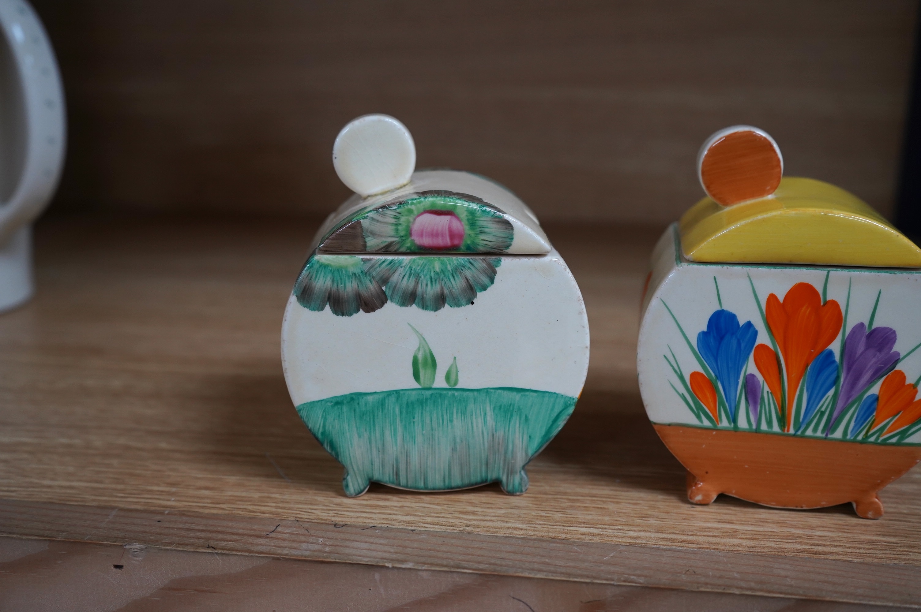 Two Clarice Cliff drum shaped preserve pots and covers, one in Crocus pattern and the other in Viscaria pattern. Condition - good